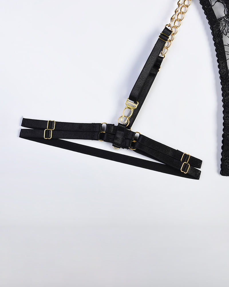Black harness lingerie set with gold chain, adjustable straps, and floral lace details.