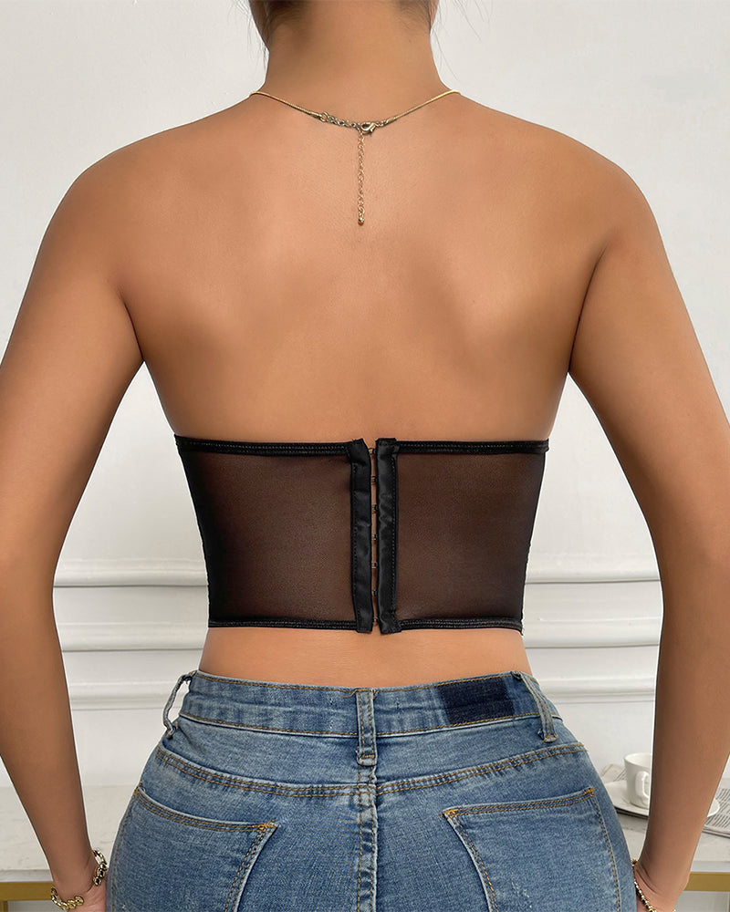 Black strapless mesh bustier top with boning, offering support and shaping, paired with jeans.