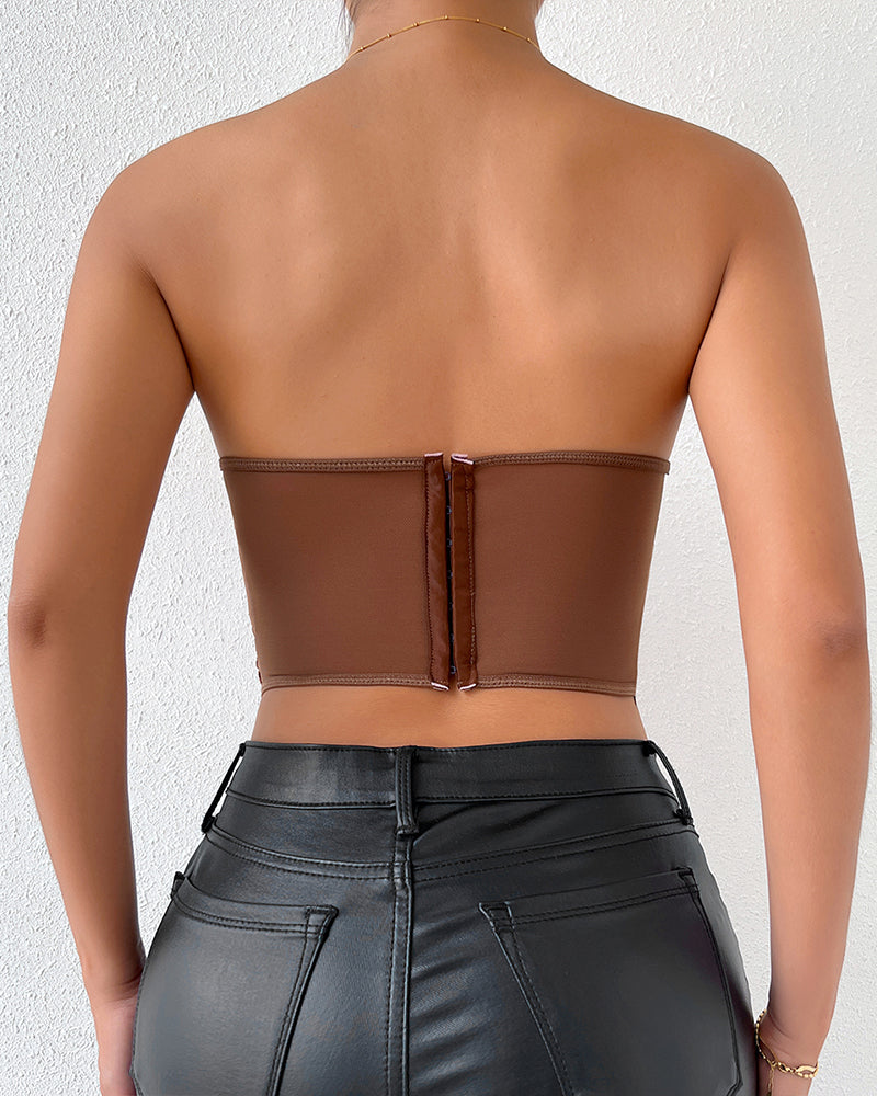 Brown strapless mesh bustier, offering waist shaping and support, paired with black leather pants.