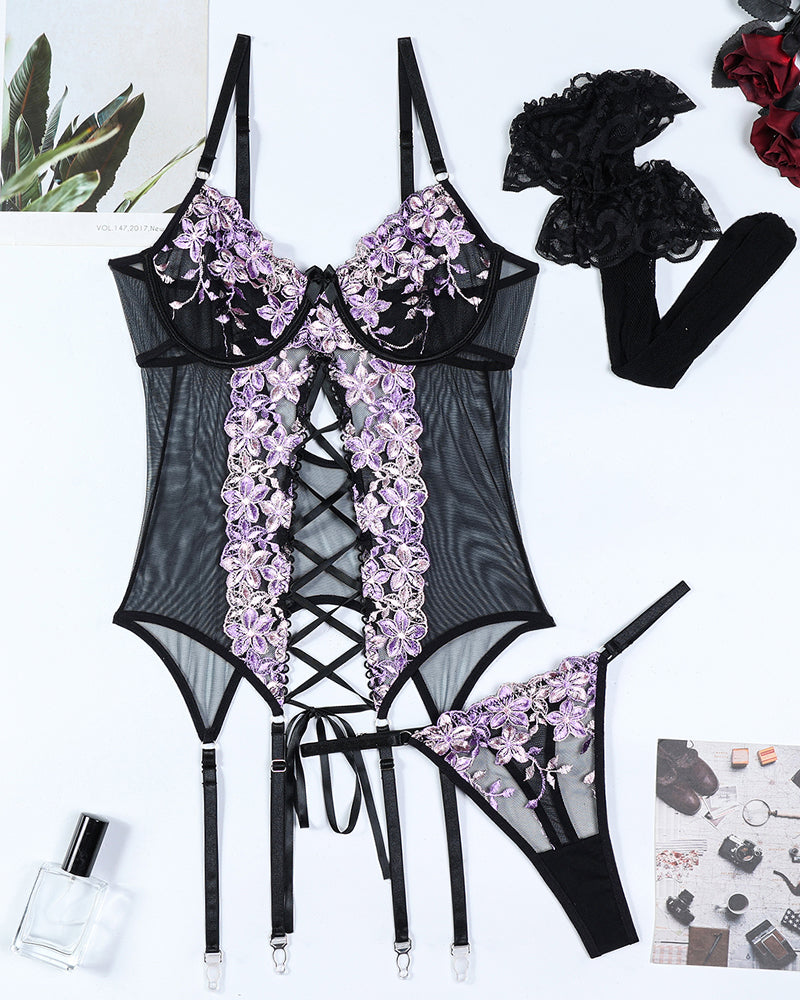 Black embroidered lingerie set with purple floral details and fishnet stockings