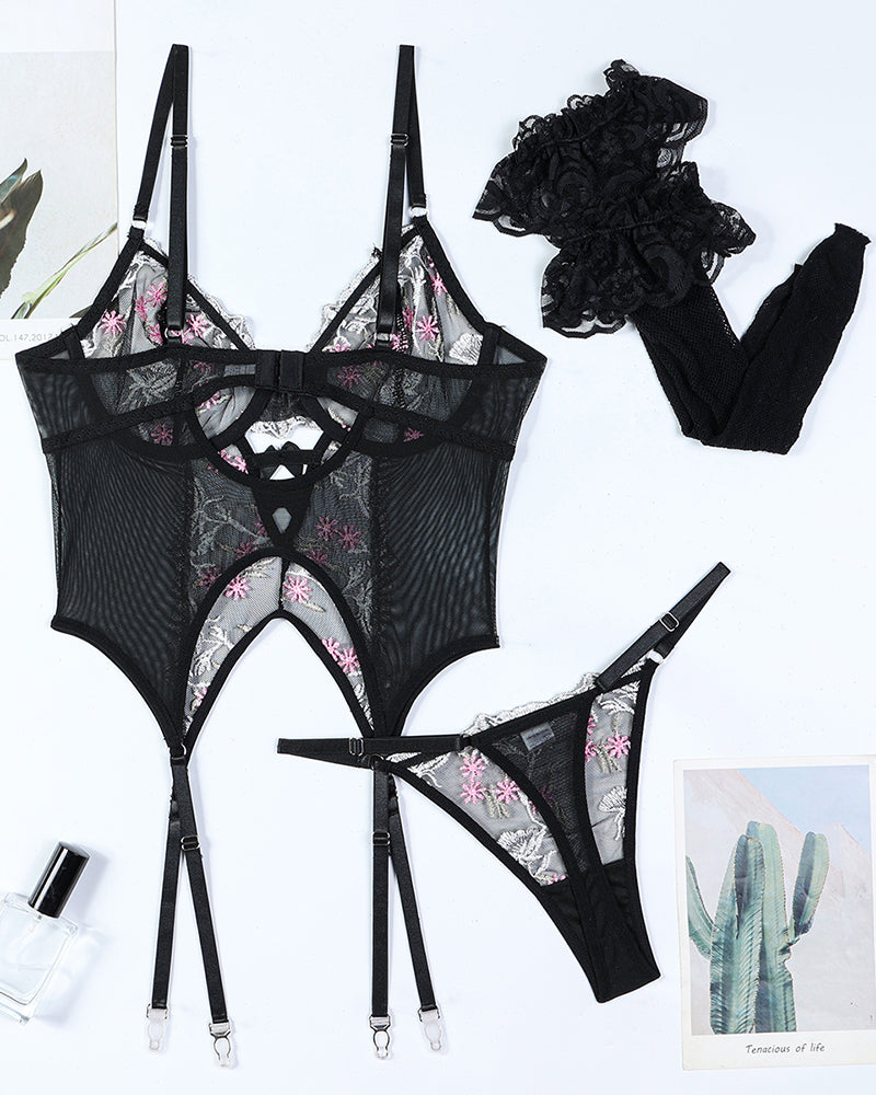 Black floral embroidered lingerie set with garter straps and stockings. Sexy sheer design for women.