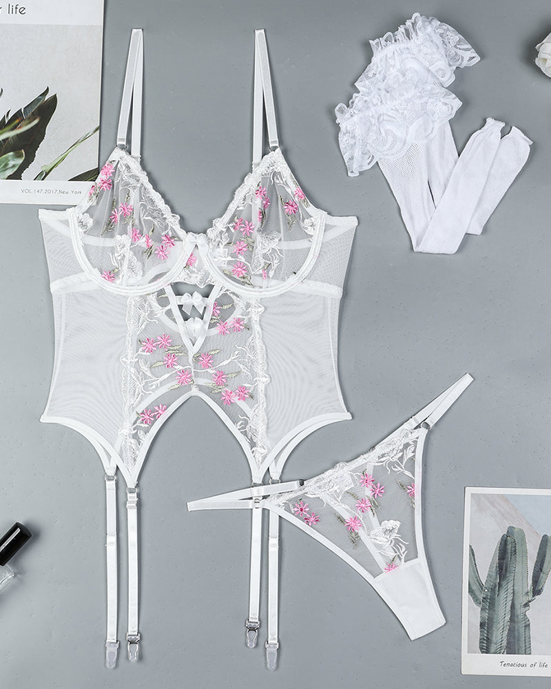 White floral embroidered lingerie set with garter straps and stockings. Sheer design.