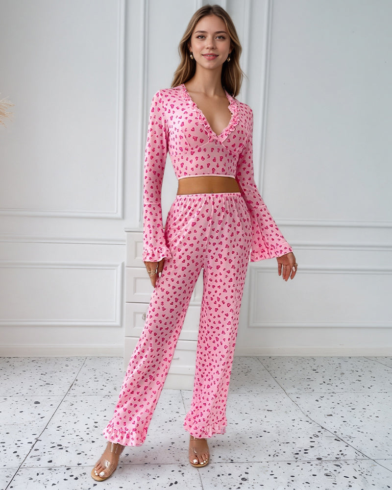Pink heart print pajama set with ruffled top and pants, perfect for comfortable sleepwear.