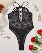 Black lace bodysuit with halter neck, metal rings, and backless design, perfect for a sensual look.