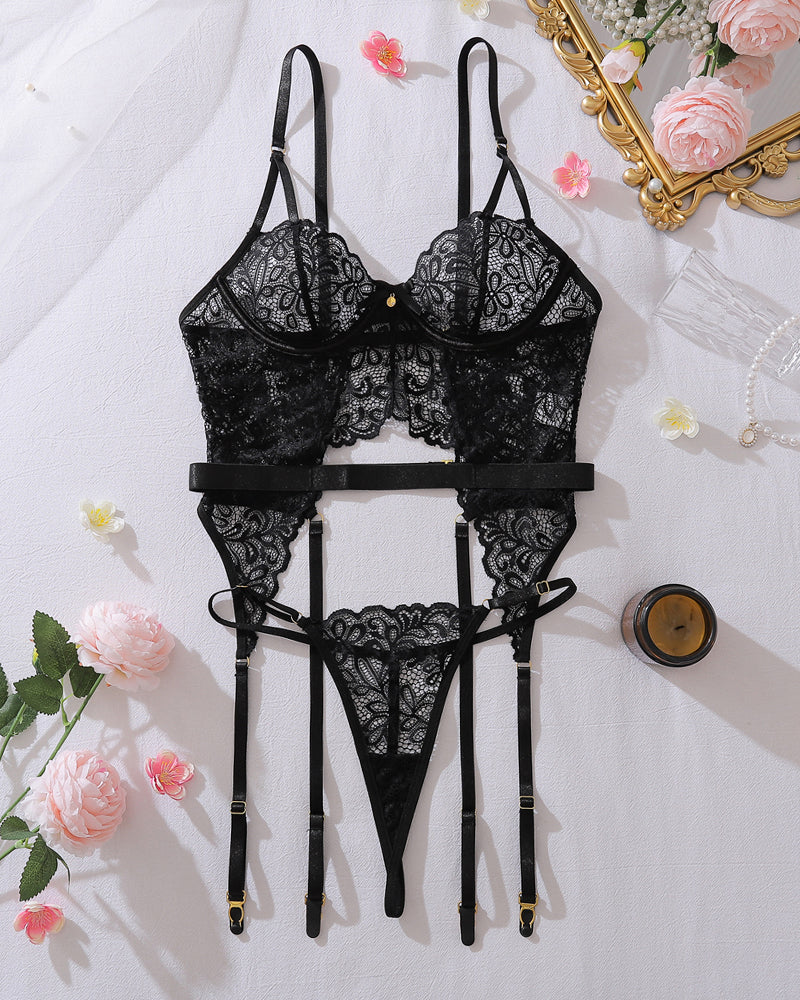 Black lace lingerie set laid flat: bra, thong, garter belt and adjustable straps