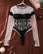 Sheer lace long-sleeve bodysuit with floral lace panel, black cutout sides, pearl-trim straps