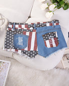 High-waisted distressed denim shorts with American flag patch pockets, frayed hem