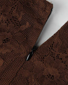 Brown lace bodysuit fabric close-up with black-trim seam detail