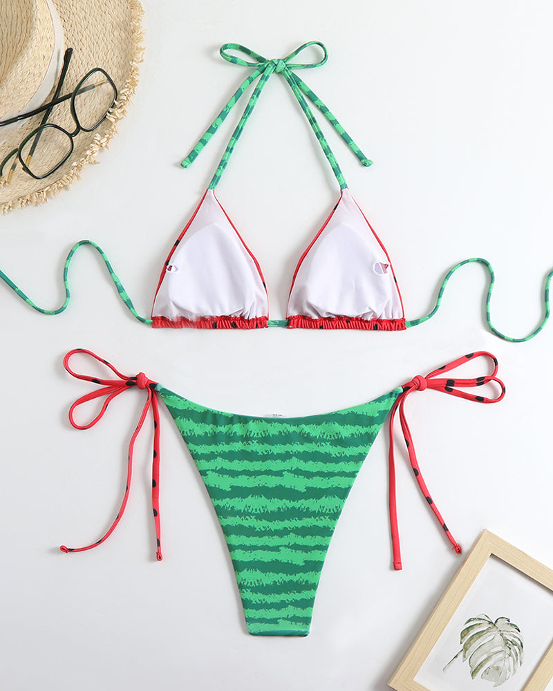 Bikini set flat lay: white triangle bikini top with green trim and striped side-tie bottoms