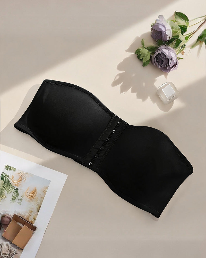 Strapless bandeau bra in black, flat lay showing smooth cups and front hook closure