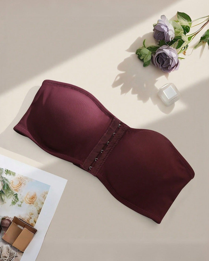 Strapless bandeau bra in burgundy, flat lay showing smooth cups and front hook closure
