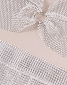Close-up of white rhinestone fringe fabric with linked metal mesh strands
