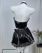 Back view of black patent halter crop top and mini skirt with choker on mannequin