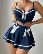 Navy sailor-style lingerie set with corset crop top, white ribbon bows, and pleated mini skirt