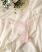 Pink sheer mesh thong with double straps, low-rise lace-front coverage.