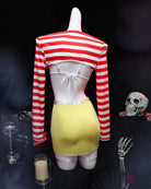 Mannequin back view: striped long-sleeve top with tied back and yellow mini skirt.