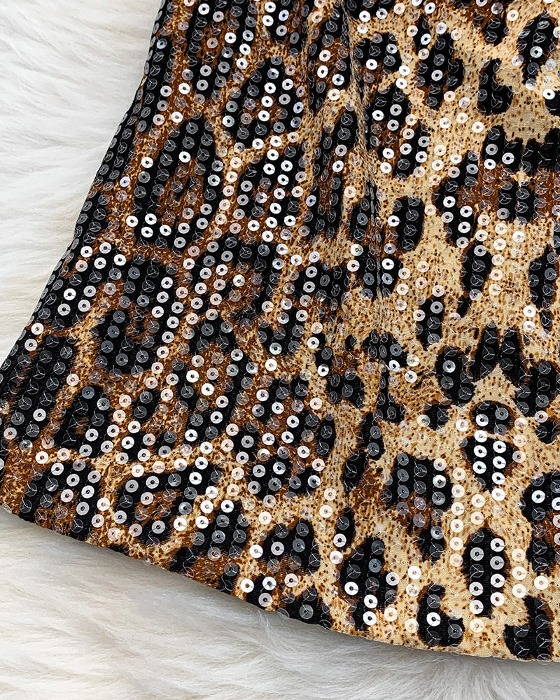 Leopard sequin fabric with black base and tan spots, full sparkle close-up