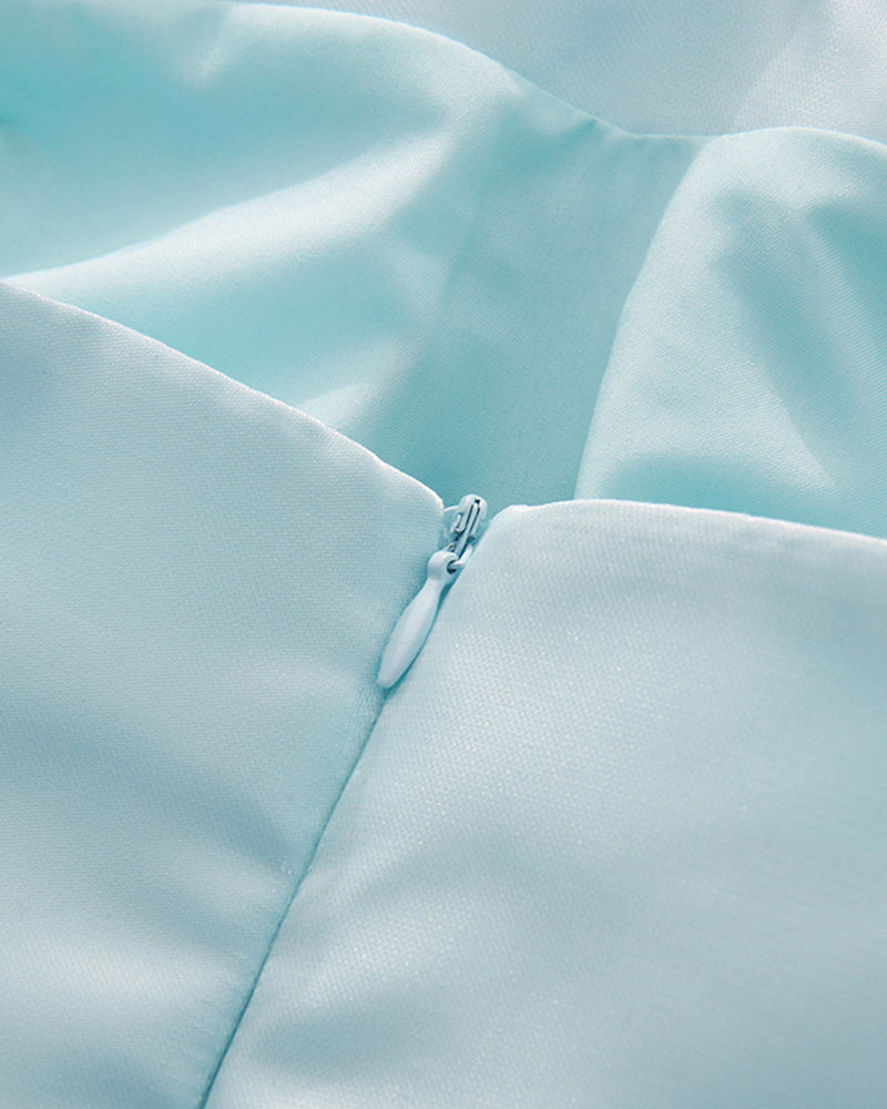 Close-up of sky blue fabric corset seam with a small decorative button.