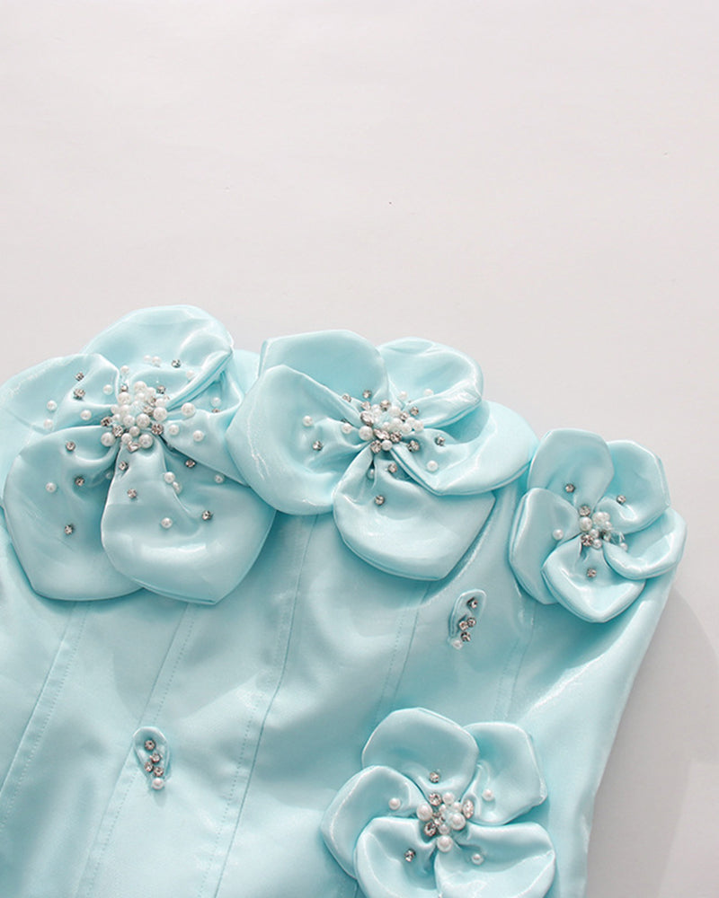 Close-up of sky blue corset with 3D floral rosettes, faux pearls, and bead clusters.