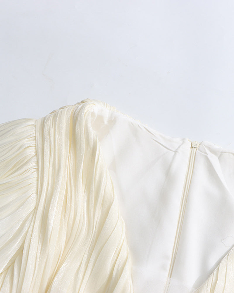 Champagne puff sleeve with pleated, layered ruffles at the cuff