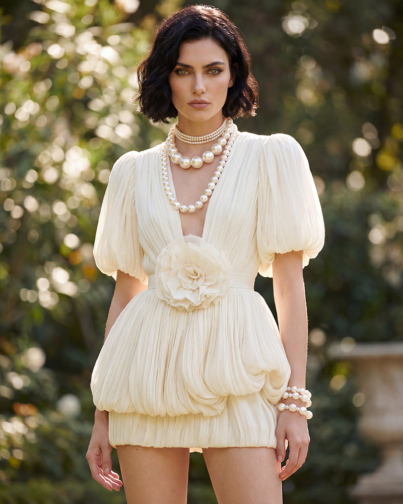 Champagne mini dress with deep V neckline, pleated puff sleeves, floral waist detail
