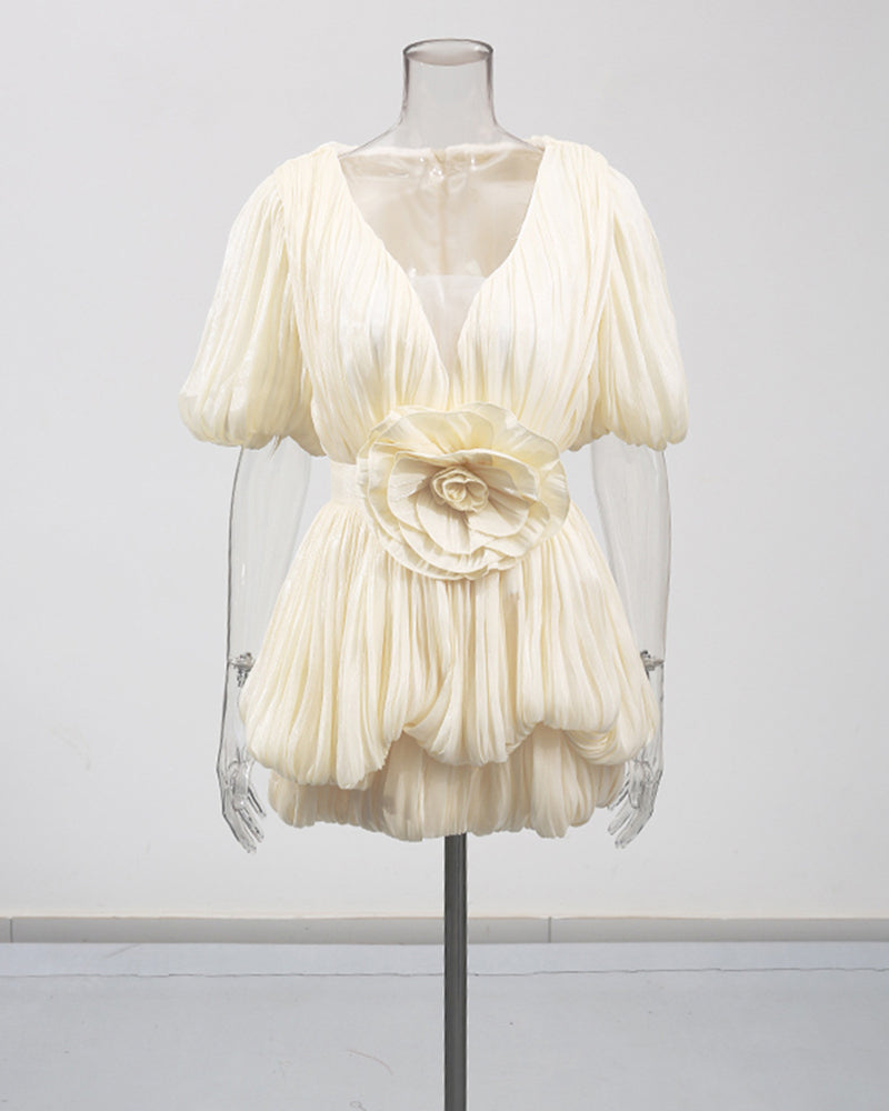 Champagne mini dress on mannequin with deep V, puff sleeves, and floral waist applique