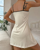 Cream mini slip dress back view with thin spaghetti straps and scooped back