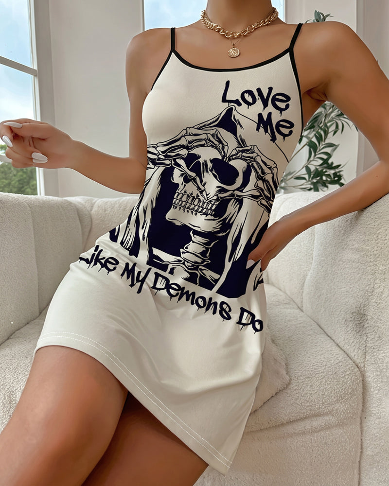 Cream mini slip dress with spaghetti straps, skull graphic and bold slogan print