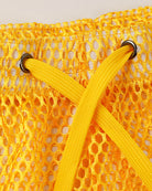 Yellow open mesh shorts close-up with drawstring and metal eyelets.