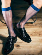 Sheer mid-calf dress socks with dark blue band at top, worn with black dress shoes