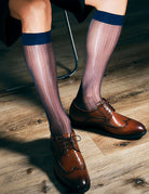 Sheer mid-calf dress socks with dark blue band at top, worn with brown lace shoes