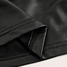Black metallic crop top close-up of ruched seam and stitched hem edge.