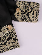 Baroque prince coat sleeve and cuff with ornate gold embroidery on dark fabric