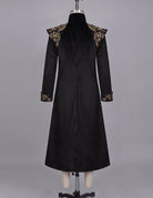 Black long frock coat on mannequin with gold baroque trim at shoulders and cuffs