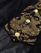 Close-up of black coat cuff panel with gold baroque embroidery and round buttons